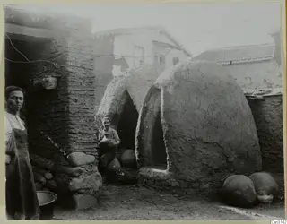 Two domed clay kilns in a potter's yard at Klirou, with two people standing nearby.