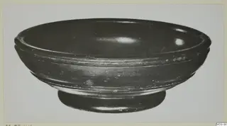 Black-glazed pottery bowl with a low ring foot and two grooves on the outer wall.