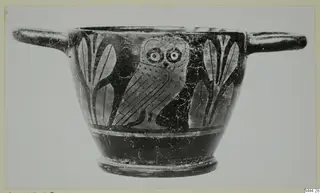 Two-handled black-glazed cup with a painted owl between upright leaf motifs