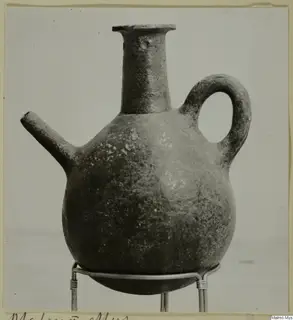 Red Polished III jug with a side spout and loop handle, standing on a wire stand