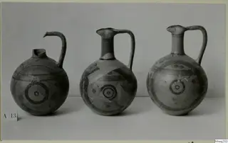 Three painted jugs from Amathus, standing in a row against a plain backdrop.