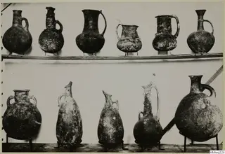 Eleven pottery jugs and jars from Cyprus, shown in two rows at the Cyprus Museum