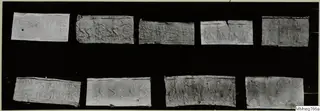 Nine rectangular pieces with raised or incised designs, laid out in two rows on a black background.