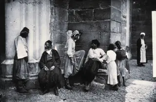 Nicosia: a group of men by a column and a stone wall, 1981 contact print