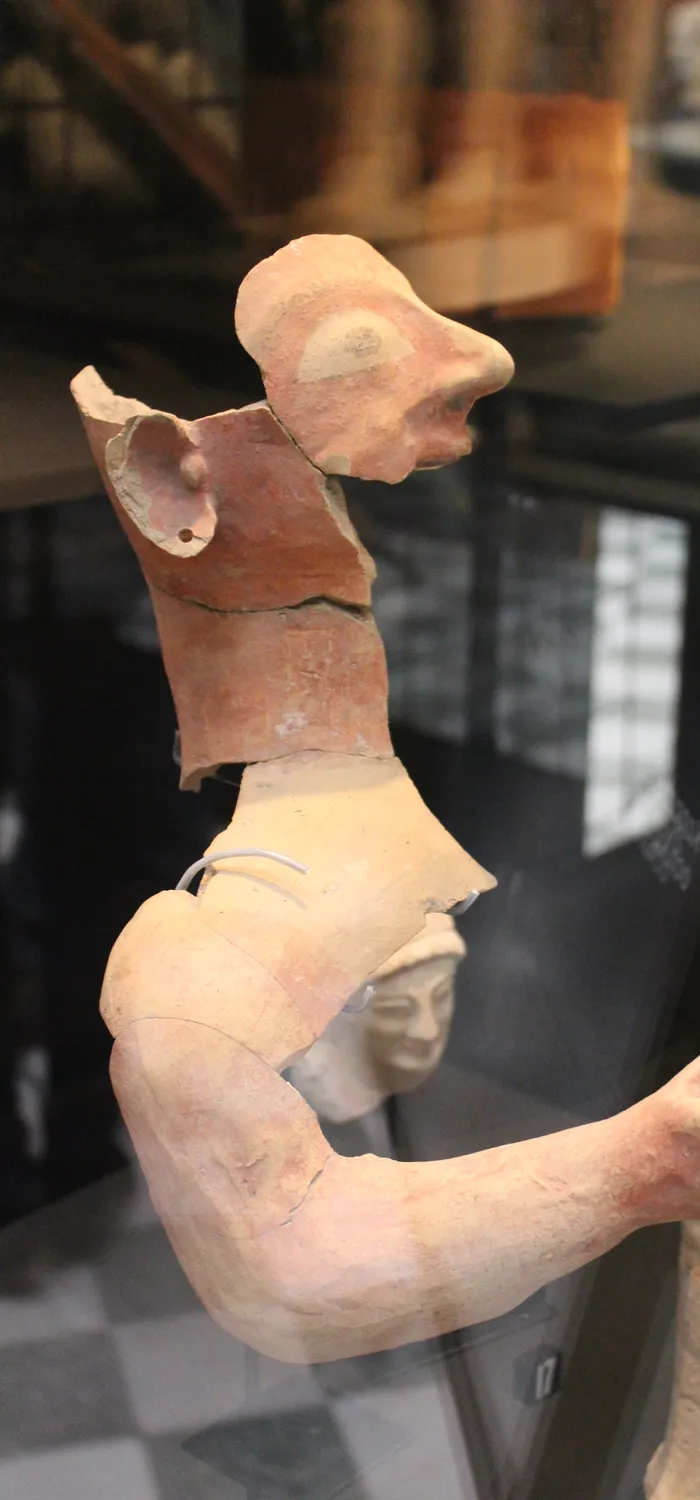 Large terracotta male votary from the sanctuary at Ayia Irini, shown in profile with a hooked nose and one forearm raised; Medelhavsmuseet, Stockholm.