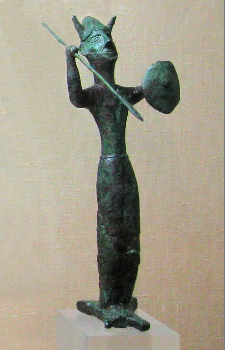 The Ingot God from Enkomi: a horned bronze warrior raising a spear, a small round shield on his other arm, standing on a base shaped like a miniature oxhide ingot. Cyprus Museum, Nicosia (photo: Gerhard Haubold, GFDL).