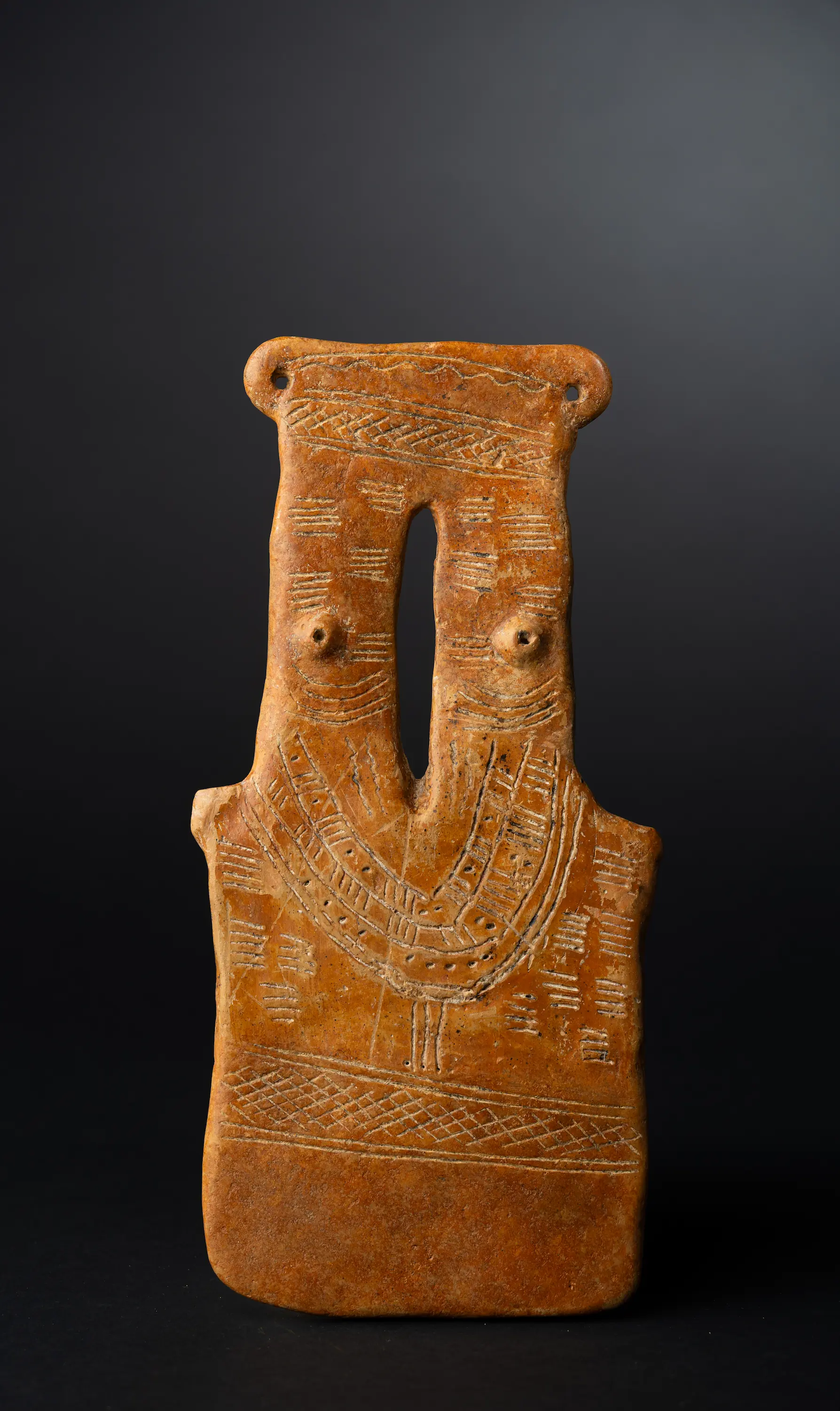 The two-necked figure seen from the front: two necks bridged at the top, a deep collar of arched dotted strands across the chest, and two small pellet breasts set on a single torso. (Drakopoulos collection)