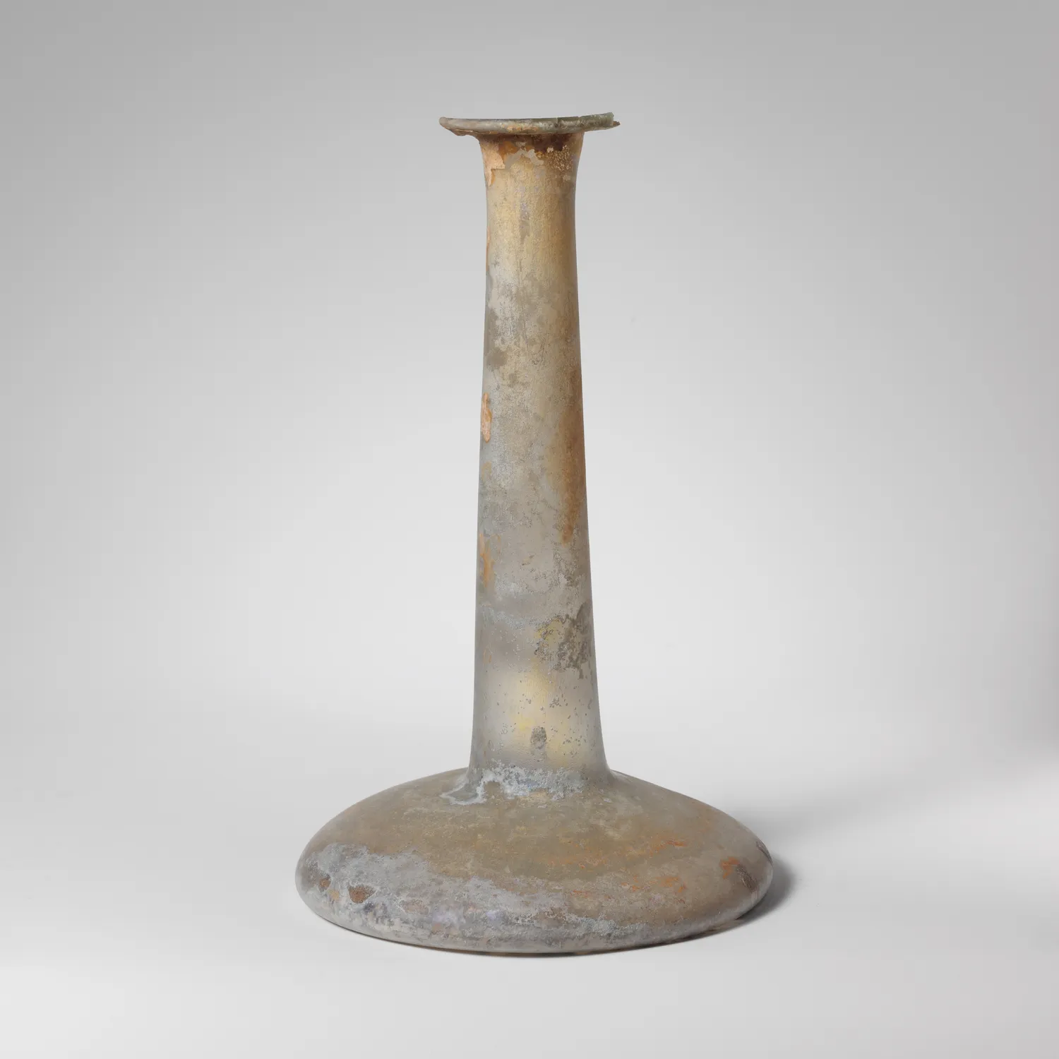 A Cypriot glass perfume bottle of the kind that filled the early saleroom shelves, its surface gone iridescent with burial; Roman, 2nd–3rd century CE. (Metropolitan Museum of Art, the Cesnola Collection, 74.51.16; public domain.)