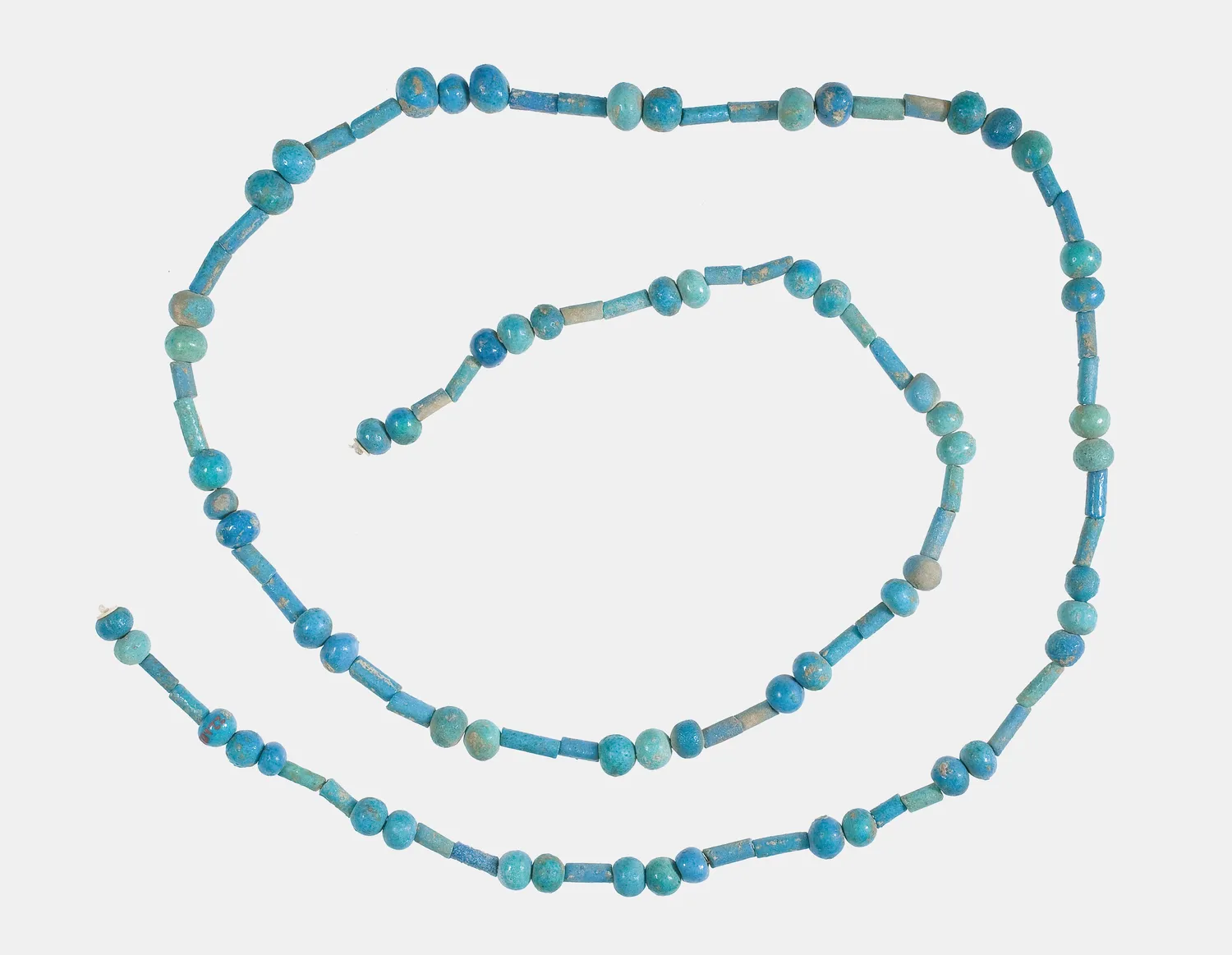 An Egyptian string of blue faience ball and cylinder beads, about 1800 to 1450 BC, its glaze largely intact. The Cypriot necklace belongs to the same globular family. The Met.