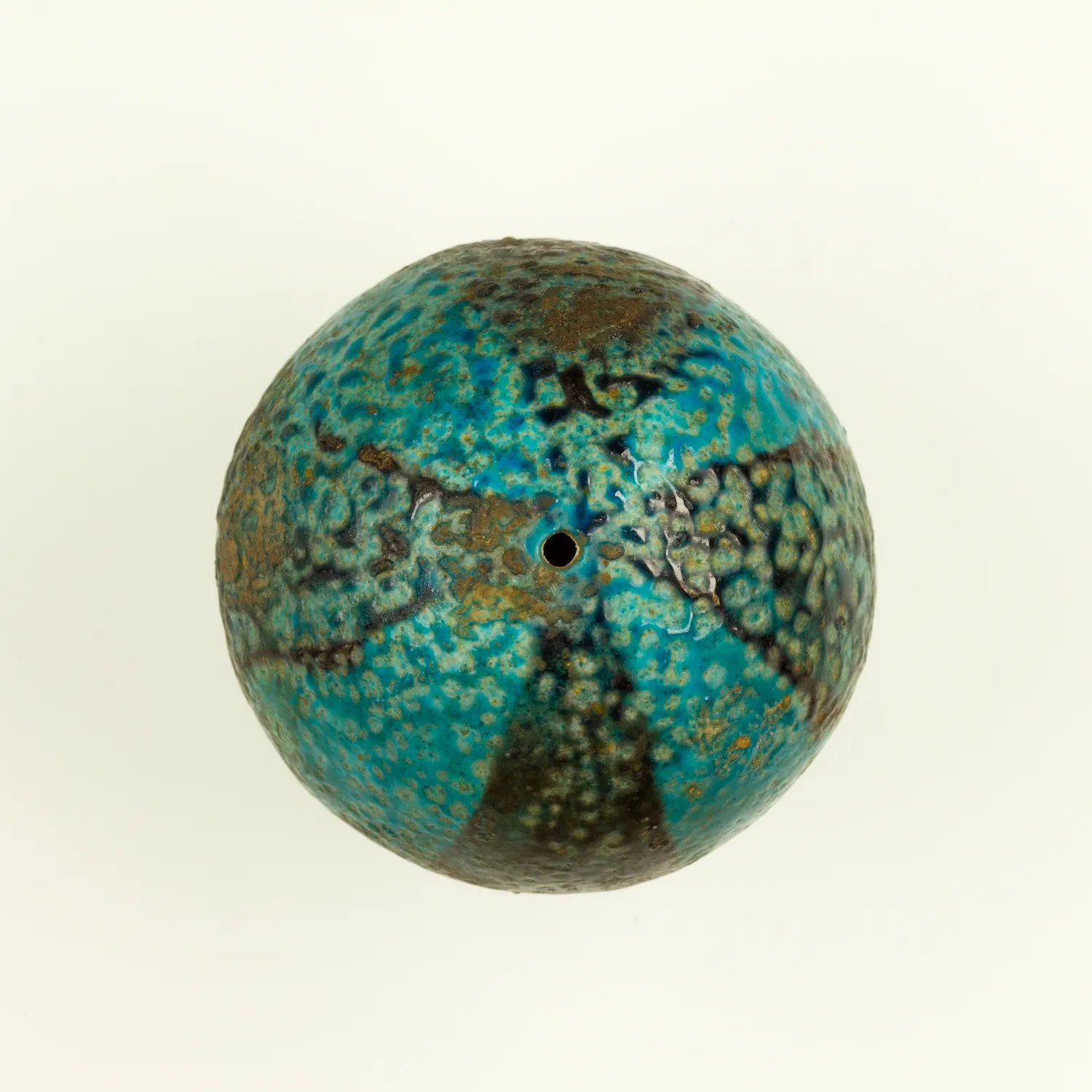 A single faience ball bead with its copper-blue glaze and central string-hole preserved, the look these beads had when new. The Met.