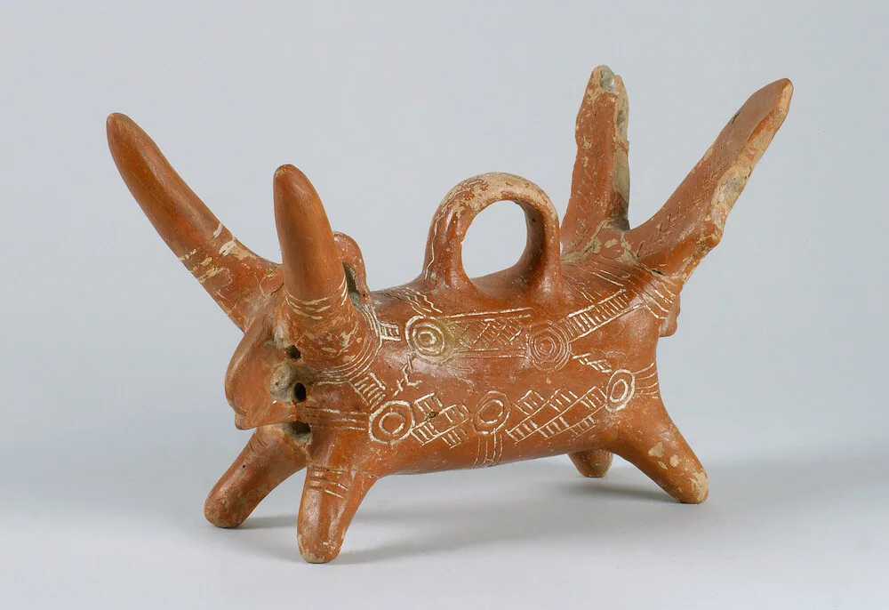 A near-identical Red Polished animal vase with a horned head at each end, the body covered in white-filled concentric circles and a loop handle over the back. Ashmolean Museum, Oxford, AN1971.856, c. 2100 to 1850 BC.