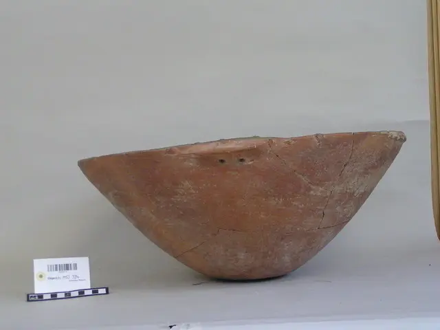 Large shallow bowl of lightly burnished red-ware with a series of small lugs round rim with two smaller ones for handles, Early Bronze Age II Cypriot