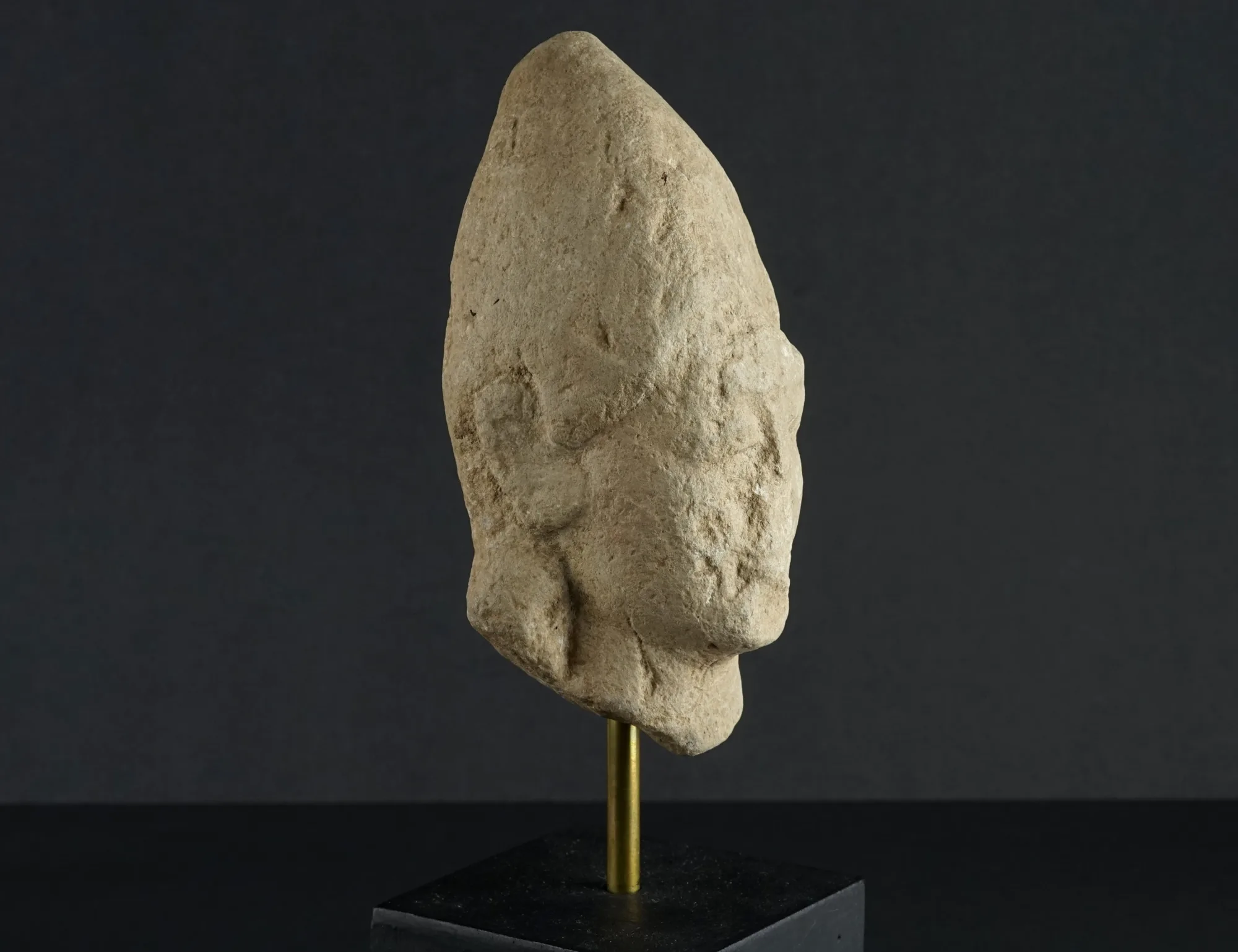 Weathered Limestone Head of a Votary in a Tall Pointed Cap, Archaic II Cypriot statue