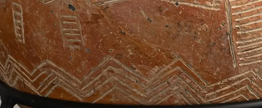 Detail of the lower body: a broad band of incised zigzags below the hatched panels.
