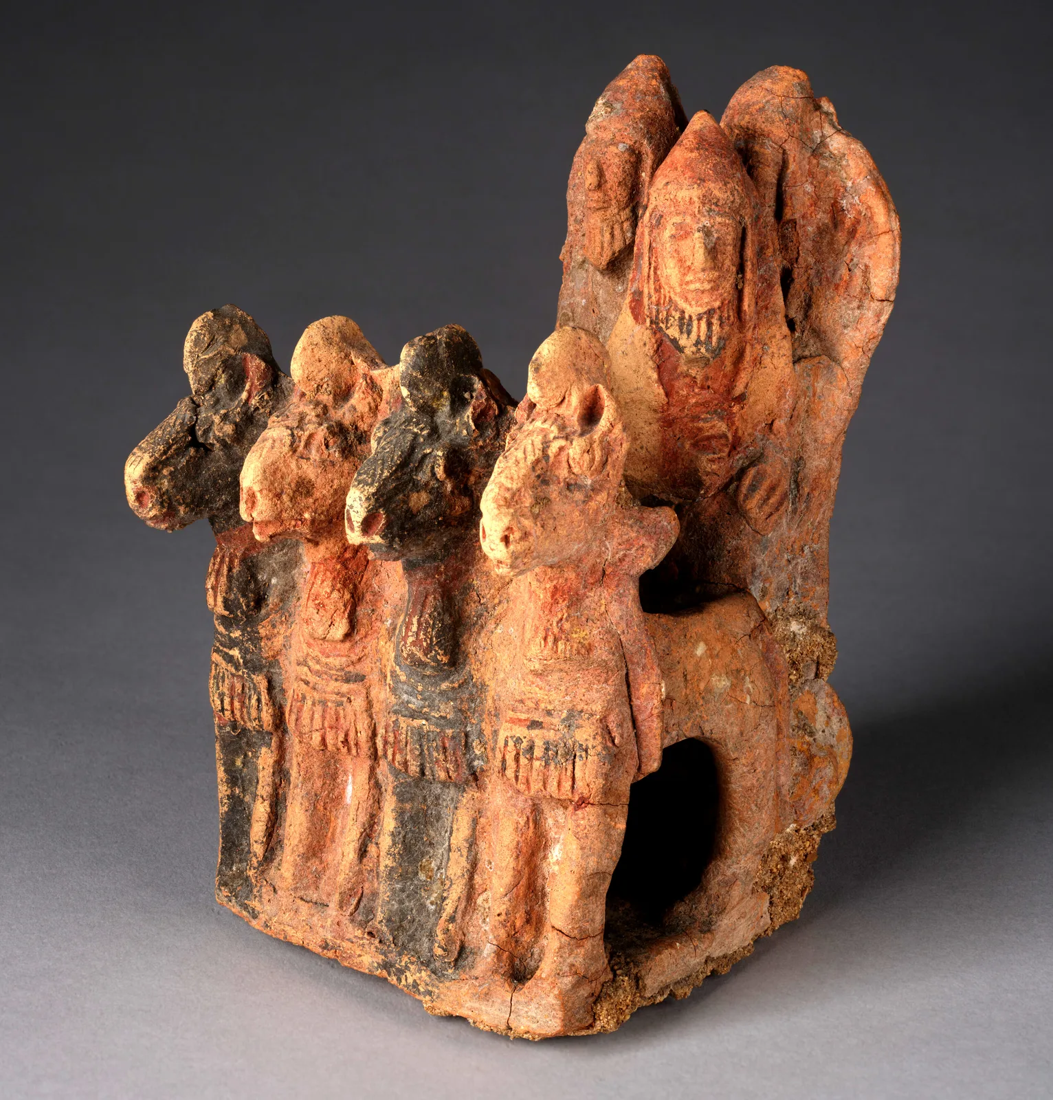 Terracotta model of a chariot drawn by four horses abreast, with three helmeted figures standing in the car behind them