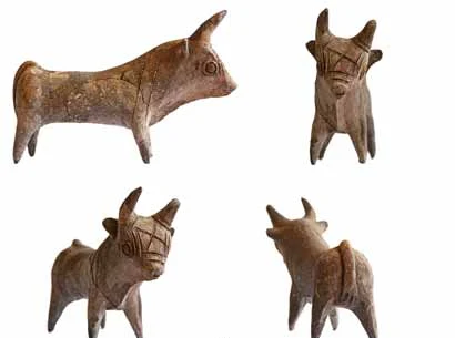 Four views of a small grey-brown clay bull with short horns, round applied eyes and incised lines on the head and body