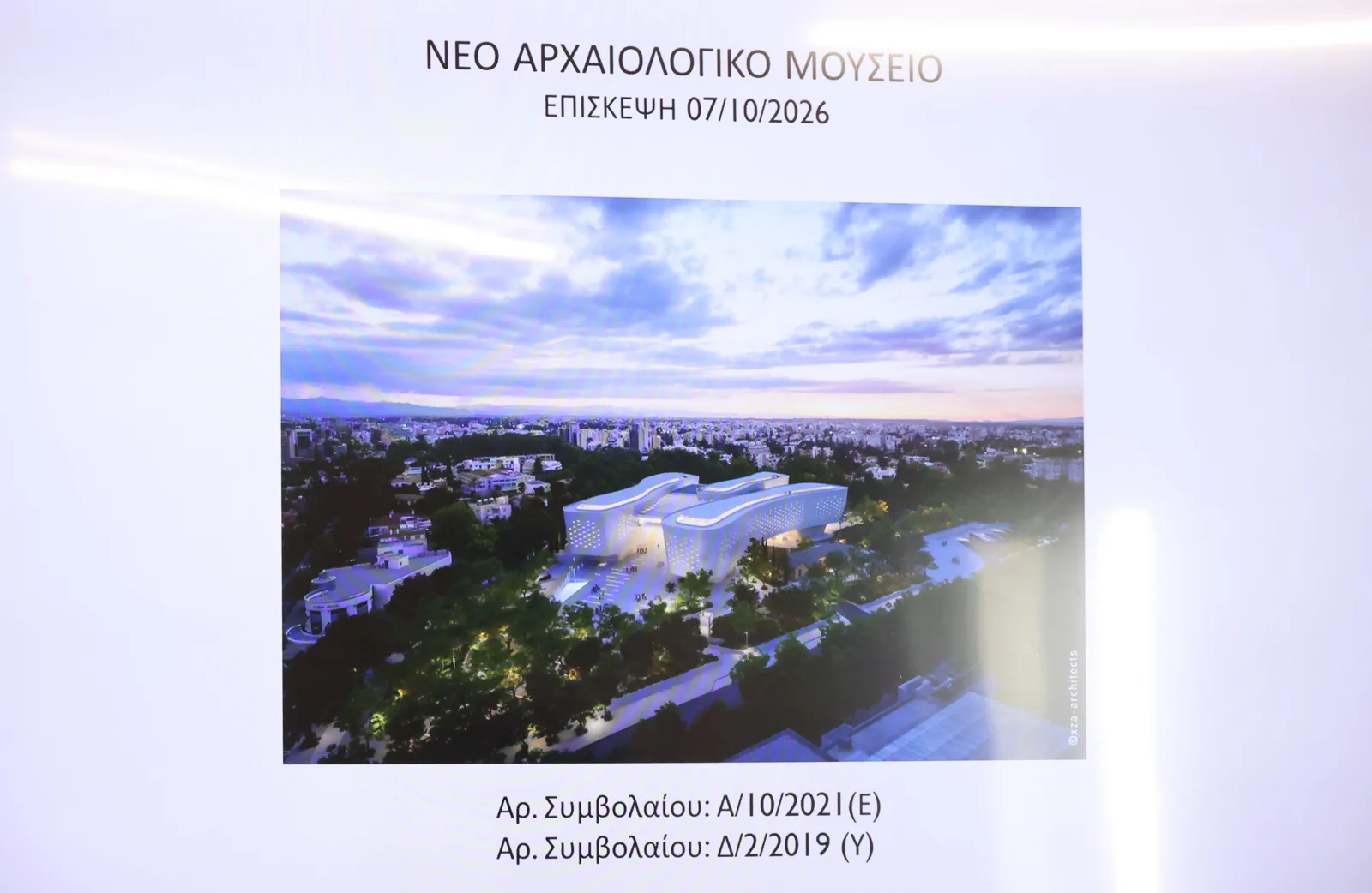 Projected slide headed in Greek New Archaeological Museum, Visit 07/10/2026, showing an aerial rendering of a long white building among trees in Nicosia at dusk