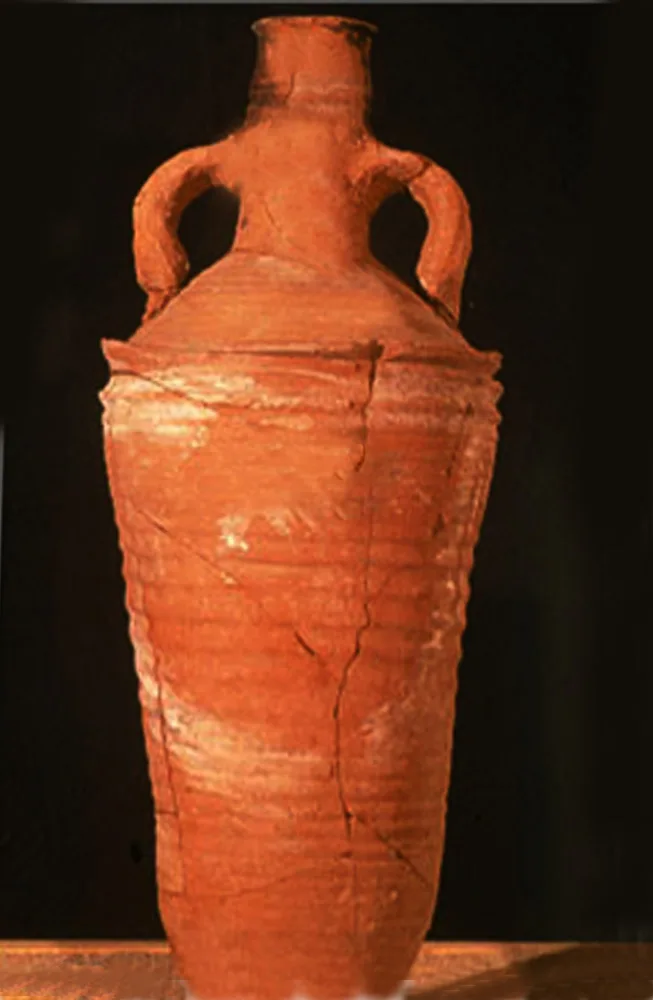 A tall orange-red clay jar with two looped handles high on the shoulder, a narrow neck and ribbed body, against a black background