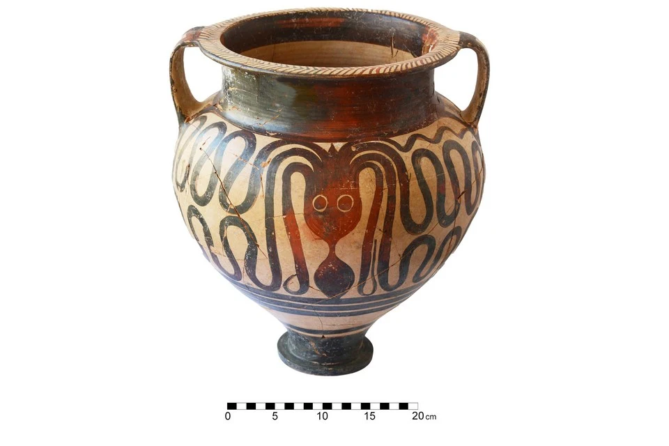 Two-handled pottery bowl on a low foot, painted on a pale ground with a dark octopus whose wavy tentacles cover the body, beside a 20 cm scale bar