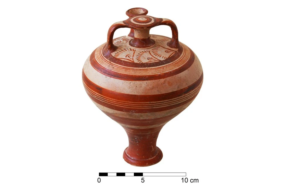 Round pottery jar with a false neck between two small handles and a spout, painted with red-brown bands and a frieze of curving motifs on the shoulder, beside a 10 cm scale bar