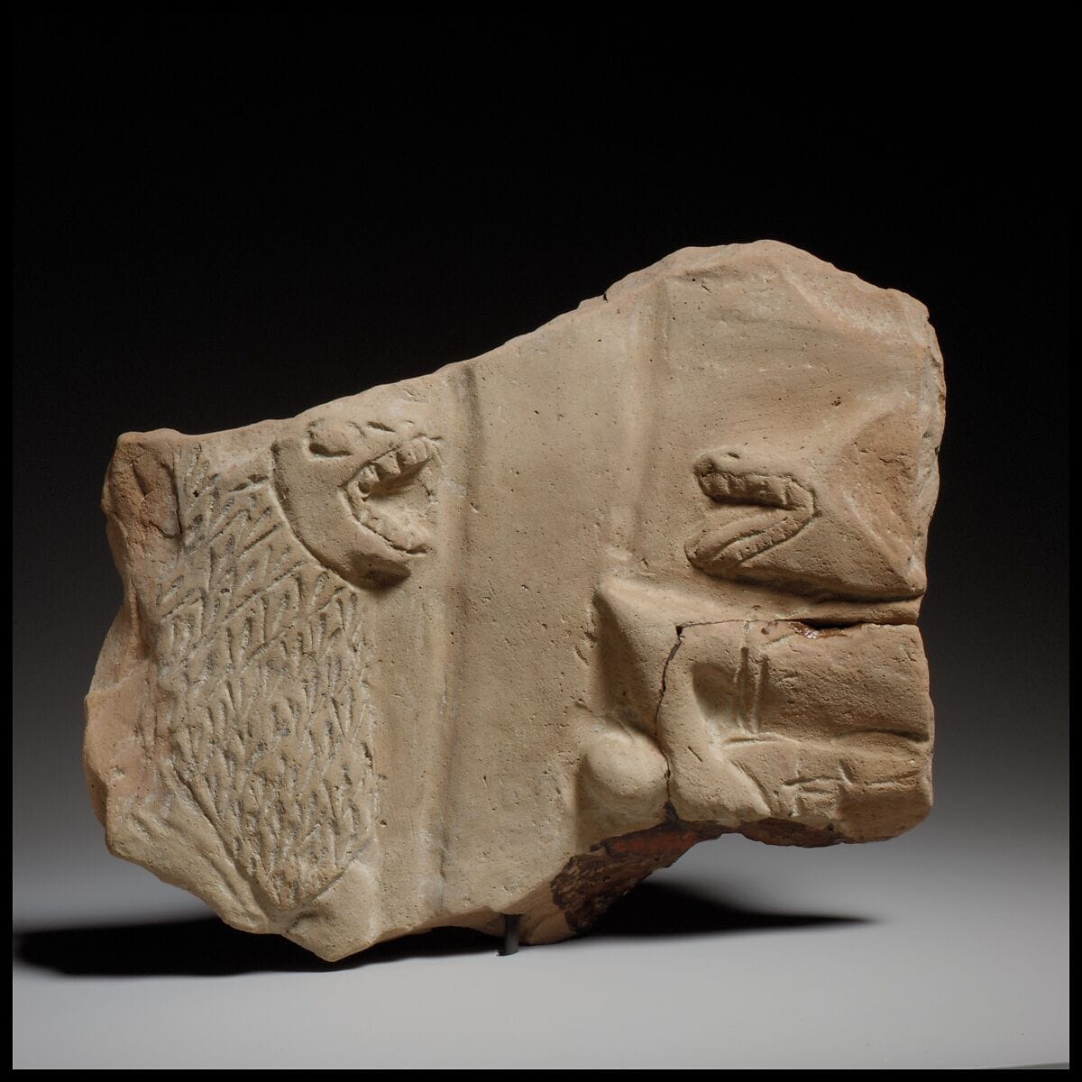 Fragment of a large terracotta statue of a man, Archaic II Cypriot weapons & armour
