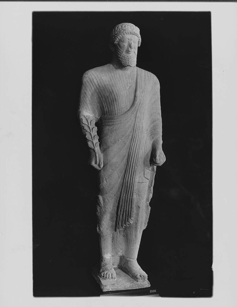 Limestone votary of a bearded male in Greek dress with a wreath, Archaic II Cypriot statue