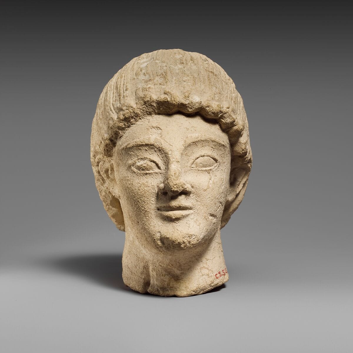 Limestone head of a beardless male votary, Archaic II Cypriot statue