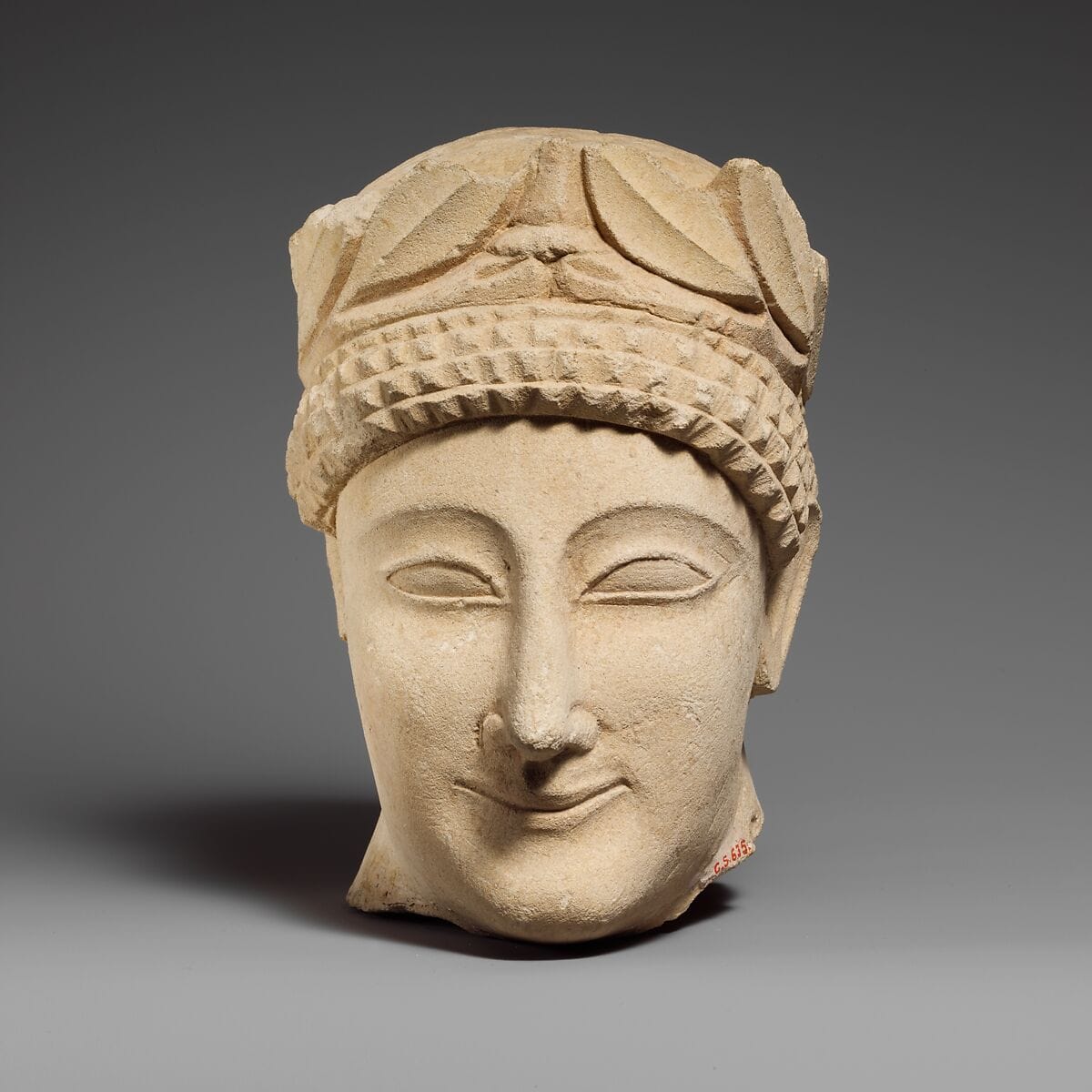 Limestone head of a beardless male votary with a wreath of leaves, Classical Cypriot statue