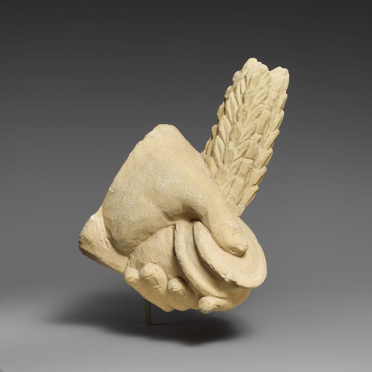 Limestone hand holding a pyxis and a branch of leaves, Hellenistic Cypriot statue