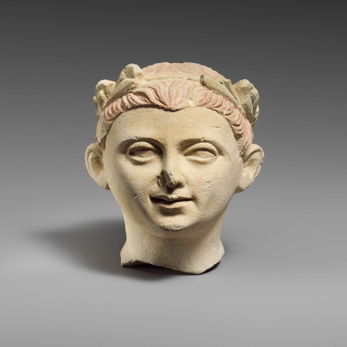 Limestone head of a boy with a wreath of leaves, Classical Cypriot statue