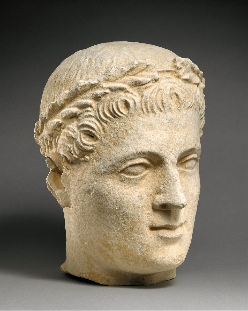 Limestone head of beardless male votary with wreath of leaves, Hellenistic Cypriot statue