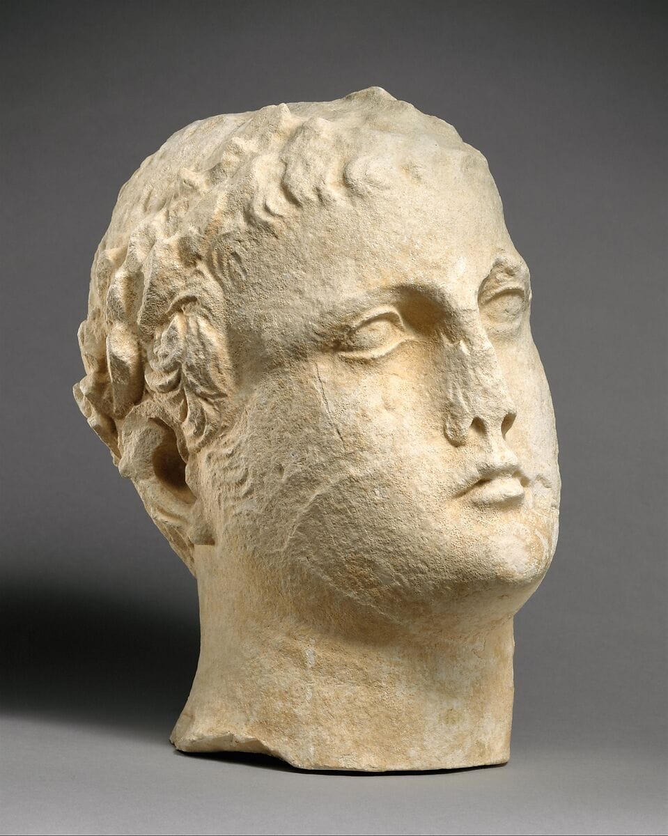 Limestone head of beardless male votary with wreath of leaves, Hellenistic Cypriot statue