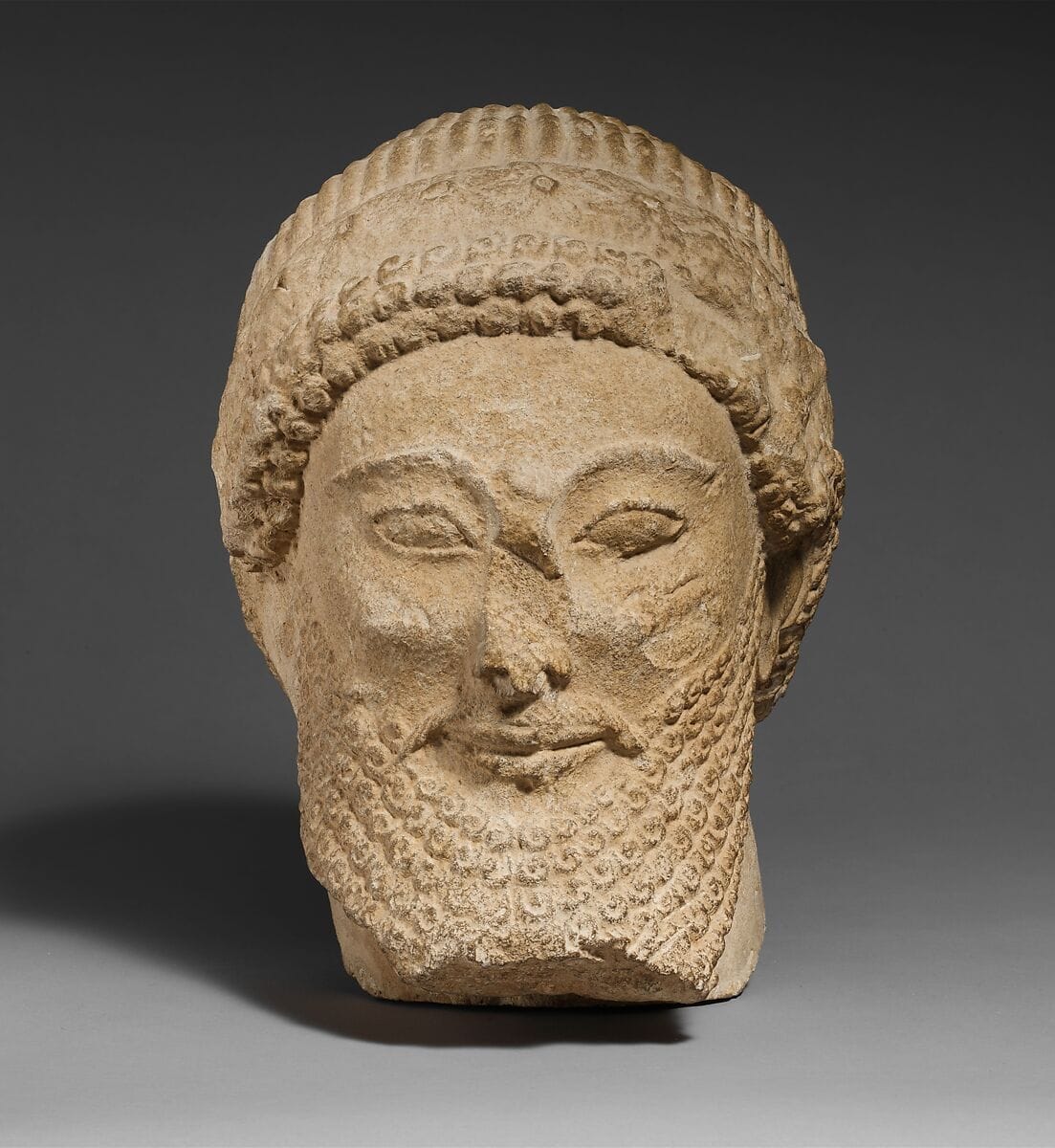 Limestone head of a bearded male with a wreath of flowers, Archaic II Cypriot statue