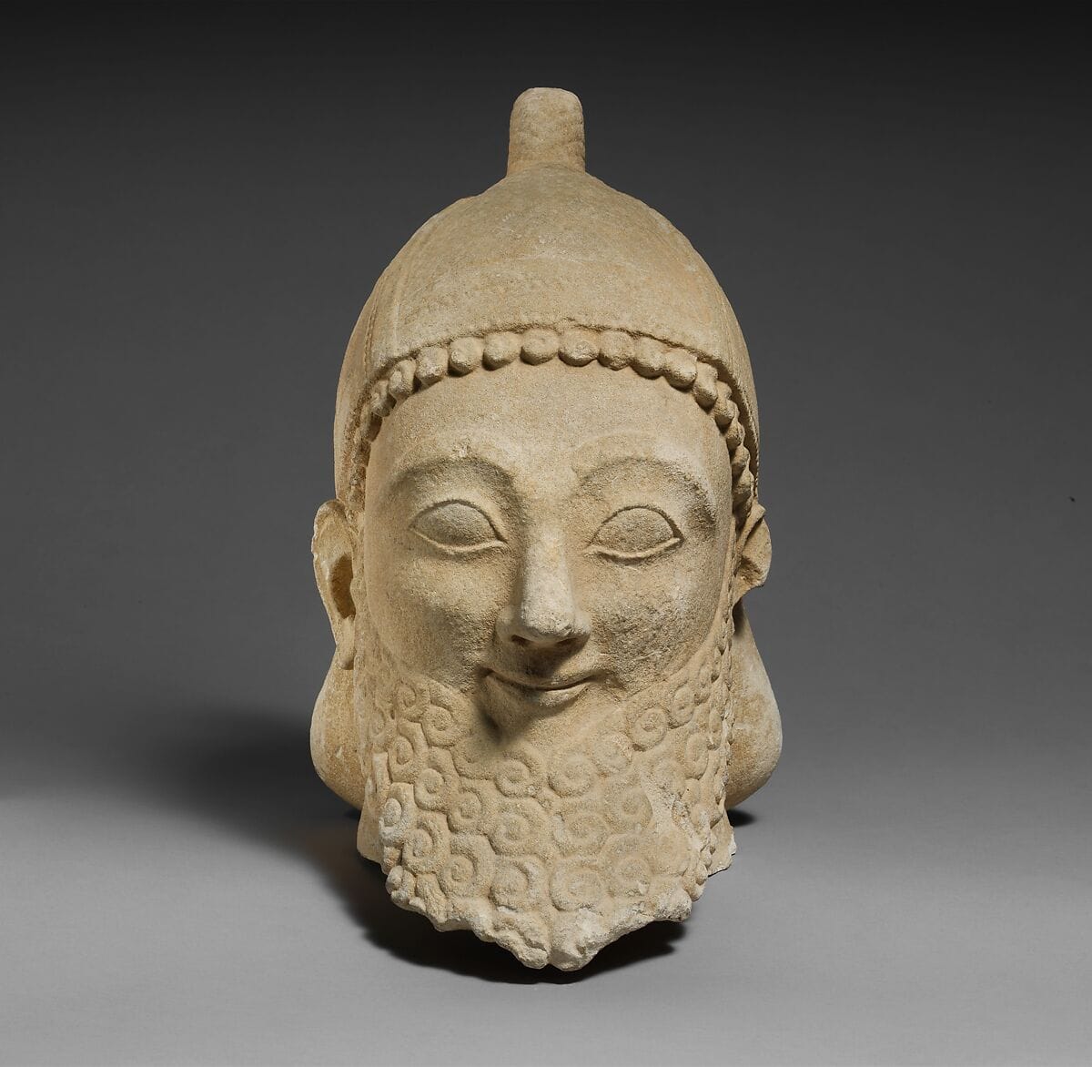 Limestone head of a bearded male wearing a conical helmet, Archaic II Cypriot statue