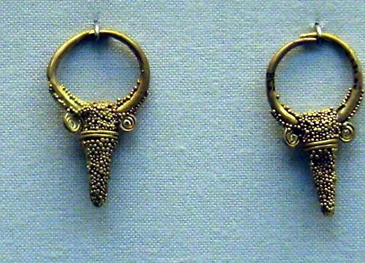 Two gold hoop earrings, each with a cone-shaped pendant covered in tiny gold granules