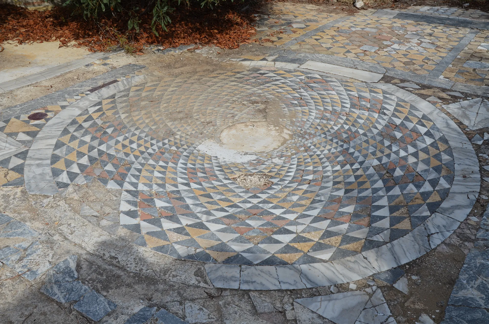 A circular geometric pavement in black, white and ochre