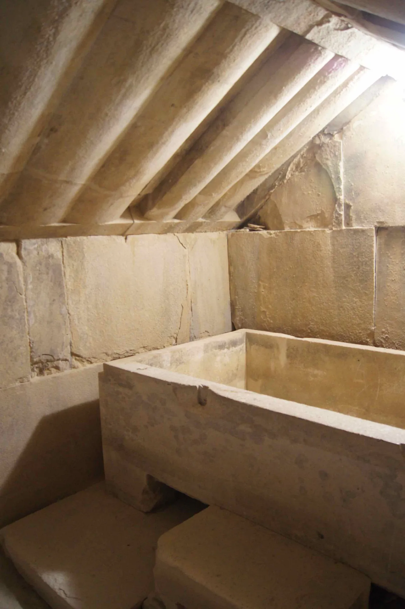 Burial chamber of a royal tomb at Tamassos, with the ceiling carved as timber beams and a plain stone sarcophagus. Photo: Rjdeadly, resized, CC BY-SA 4.0